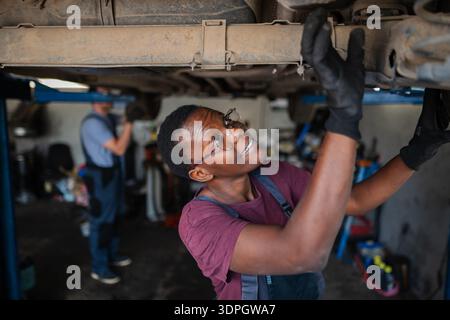 Young african female mechanic repairing car in a workshop Stock Photo