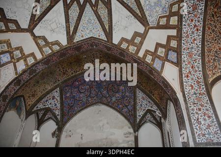 Ornate islamic architectural interior with pointed arches and vaulted ceiling covered in colorful floral tile mosaics and geometric patterns, historic Stock Photo