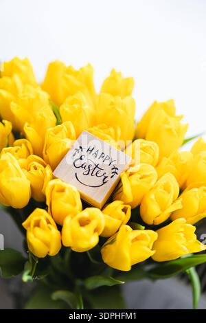 Spring festive composition with yellow tulips and decorative eggs Stock Photo