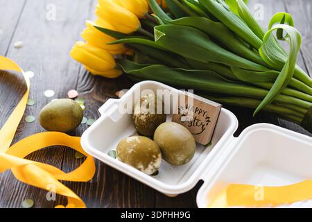 Spring festive composition with yellow tulips and decorative eggs. Easter holiday Stock Photo