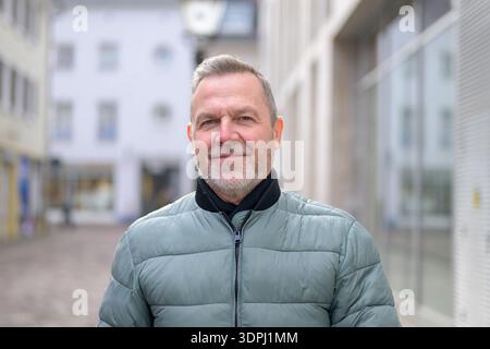 Close up of a confident mature man standing outdoors in a modern city street, representing leadership, experience, professionalism and a healthy lifes Stock Photo