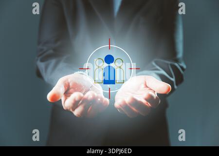 Targeted recruitment concept with businessman holding glowing people icon inside crosshair, representing talent acquisition, workforce selection and H Stock Photo