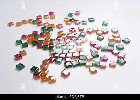 a background made with some colored glass tiles scattered on a white surface Stock Photo
