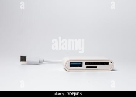 Compact white USB-C multiport adapter with integrated short cable, USB-A port, and SD card reader for fast data transfer and device expansion Stock Photo