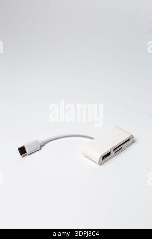 Compact white USB-C multiport adapter with integrated short cable, USB-A port, and SD card reader for fast data transfer and device expansion Stock Photo
