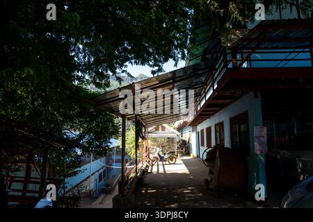 Sunlight filters through a tree onto a covered walkway at a school in the Mae La refugee camp, Tak Province, Thailand. Stock Photo