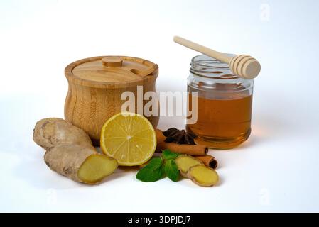Glass jar of honey with lemon, ginger and mint leaves. Natural detox and immunity boosting ingredients. Stock Photo