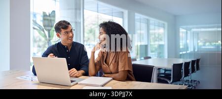 Happy busy coworkers working together on laptop computer at office meeting. Stock Photo