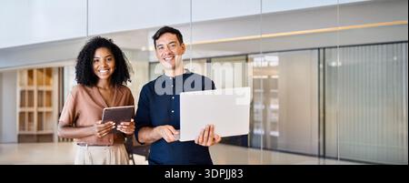 Young happy team of two diverse business man and woman in office, portrait. Stock Photo