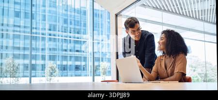 Busy manager consulting employee using laptop computer working in office. Stock Photo