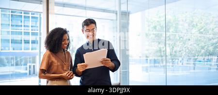 Busy business man and business woman standing in office talking about documents. Stock Photo