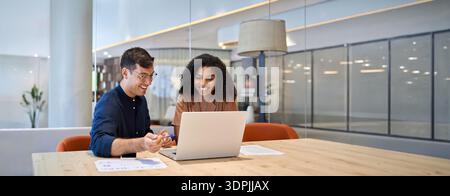 Smiling team professional employees working together on computer in office. Stock Photo