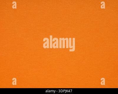 A vibrant orange canvas radiates warmth, its textured surface inviting a touch, embodying the essence of joyous energy Stock Photo