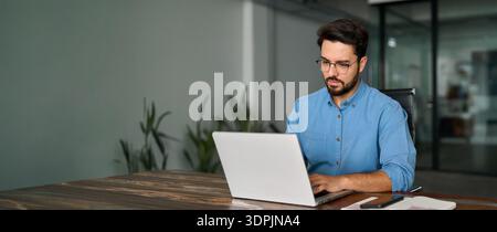 Busy professional business man using laptop working in office. Stock Photo
