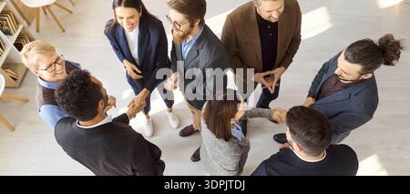 Top view of diverse business team networking with handshakes in office meeting Stock Photo