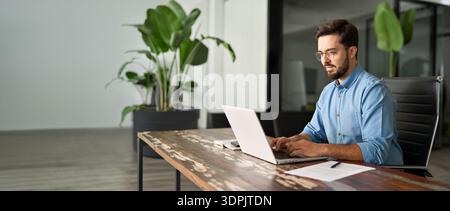 Busy professional business man using laptop working at office workplace desk. Stock Photo