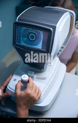 Doctor hands control the apparatus for testing the vision foe young woman Stock Photo