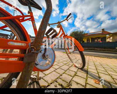 Rusted bicycle locked on a pole Stock Photo