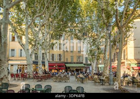 Lively outdoor cafe scene under plane trees in Aix-en-Provence, France Stock Photo