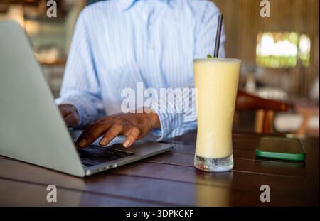 Woman entrepreneur managing her business from remote work. Working on laptop in restaurant Stock Photo