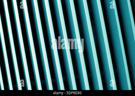 A close-up, abstract view of parallel teal and black lines angled diagonally, forming a striking geometric pattern with strong contrast and shadow Stock Photo