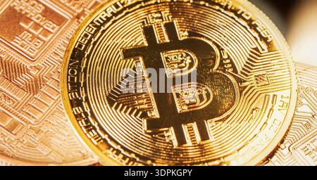 Bitcoin coin is shown in close up view with gold color and digital patterns on its surface under bright light in a modern setting. High quality photo Stock Photo