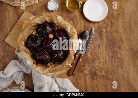 Roasted beetroots in cast iron skillet on wooden rustic table Stock Photo
