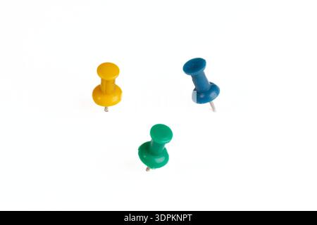 A triple set of real plastic pins in different colors, isolated on a white background with real shadows. The pins are shown in different orientations. Stock Photo