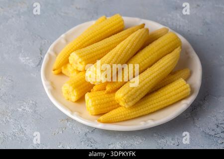 Pickled young baby corn cobs in jar Stock Photo