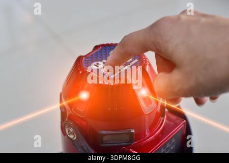 The technician is using a laser level. Stock Photo