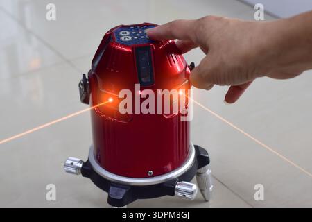 The technician is using a laser level. Stock Photo