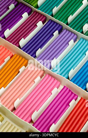 Pieces of multi-colored plasticine neatly arranged in a simple cardboard box. Close-up shot, abstract background for themes related to art supplies, c Stock Photo