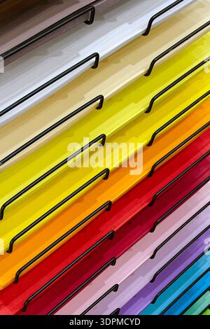Stacks of colored paper neatly arranged on the shelves of a rack. Close-up shot, abstract background for themes related to crafts, art or office suppl Stock Photo
