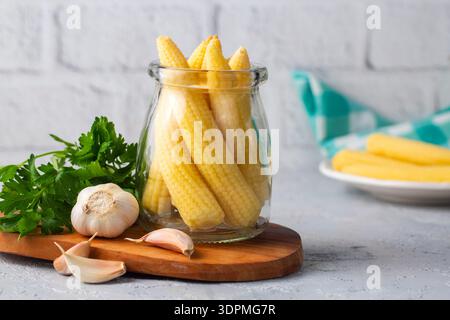Pickled young baby corn cobs in jar Stock Photo