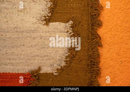 Close-up of the texture of a handwoven rug. Textured background with warm earth tones. Fine motor skills, Waldorf pedagogy, Rudolf Steiner, holistic e Stock Photo