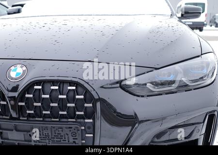 Wardenburg, Germany - Feb 6 2026 Close-up of a black BMW 4 Series G22 Coupe. Headlight, grille and logo are visible Stock Photo