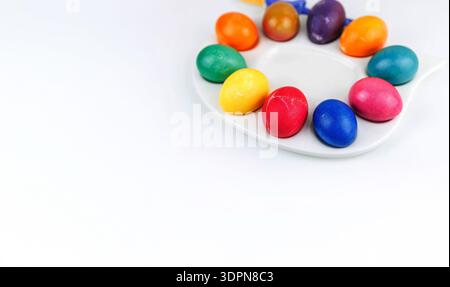Colorful dyed easter eggs arranged on duck plate, isolated on white background with copy space Stock Photo