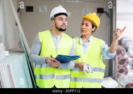 Woman and man repairers talking about documentation Stock Photo