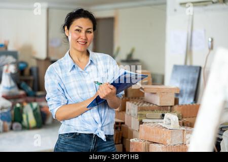Woman making notes at renovating house Stock Photo