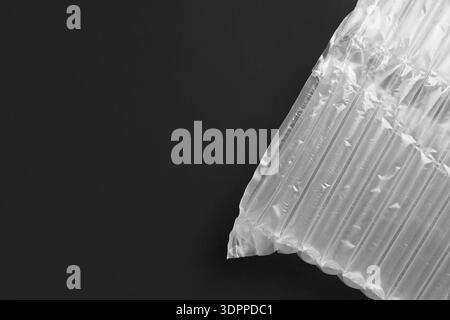Transparent air buffer packaging on black background, top view. Space for text Stock Photo