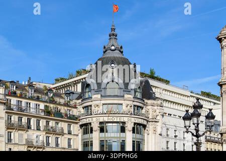 Paris, France - April 27, 2022: The dome and upper facade of Le BHV Marais department store are visible, featuring prominent signage reading 'LE BHV/MARAIS' and 'BAZAR DE L'HOTEL DE VILLE', with architectural details and a flag on top. Stock Photo