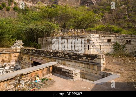 Chittorgarh, India - March 21, 2022: Stone fortification walls and an entrance structure with battlements are seen near Padan Pol, with trees, hillside, and part of the Chittorgarh Fort ramparts visible in the background. Stock Photo