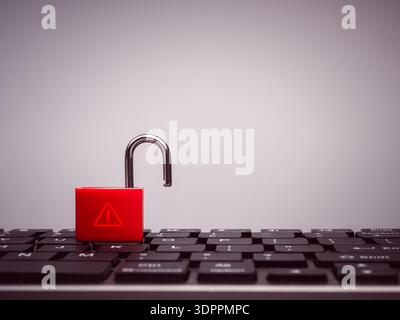 Cybersecurity concept with red unlocked padlock with warning alert icon on black keyboard computer. Symbolizes data breach, security vulnerability, ha Stock Photo