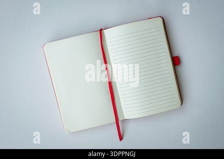 Open notebook with red bookmark. Top view, isolated on white background. Copy space. Stock Photo