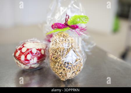 Gift wrapping of Easter eggs made from sweets and nuts in transparent foil, Easter production of regional products, Haselstaller Hof, Gechingen, Calw Stock Photo