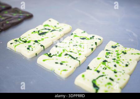 White chocolate bars with green patterns lying side by side on a table, vegan chocolate production, Haselstaller Hof, Gechingen, Germany Stock Photo