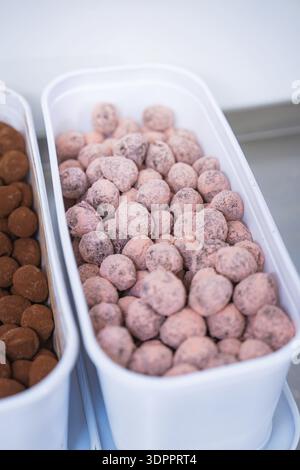 A container full of pink chocolates in a kitchen, chocolate quail eggs, Easter production, Haselstaller Hof, Gechingen, Germany Stock Photo