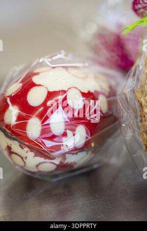 Red and white dotted Easter egg wrapped in plastic film on a metallic surface, Easter production of regional products, Haselstaller Hof, Gechingen, Ca Stock Photo
