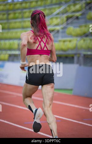 Determined woman running on a running track in a modern hall, middle distance runner Katharina Jaiser, Sindelfingen Glass Palace, Germany Stock Photo