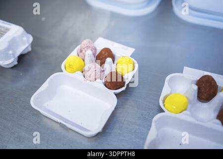 Different colored chocolate eggs in an egg carton on a metal surface, chocolate quail eggs, Easter production, Haselstaller Hof, Gechingen, Germany Stock Photo